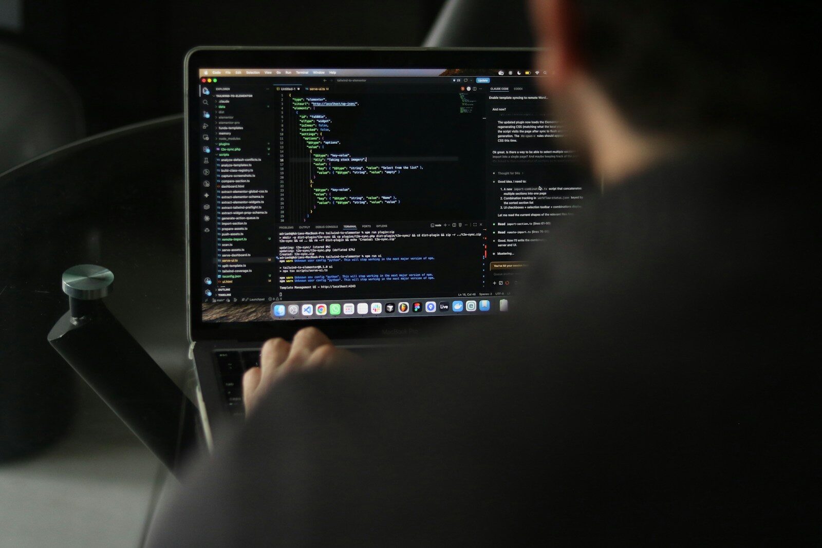 Developer typing code on a laptop screen.